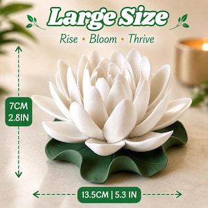 Może przedstawiać: Biała rzeźba kwiatu lotosu spoczywająca na podstawie w kształcie zielonego liścia lilii wodnej. Tekst głosi Large Size, Rise, Bloom, Thrive. Pomiary wskazują 7 cm wysokości oraz 13,5 cm całkowitej szerokości tego dekoracyjnego przedmiotu.