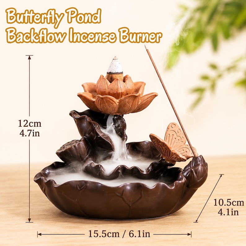 May include: A brown ceramic Butterfly Pond backflow incense burner featuring a lotus flower, a butterfly, and a leaf-shaped base. The burner measures 12 cm in height, 10.5 cm in depth, and 15.5 cm in width, with white smoke flowing downwards.