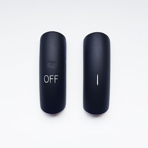 Op de afbeelding: Twee zwarte, cilindrische componenten van een elektronisch apparaat. Eén component heeft het woord "OFF" in het wit gedrukt, met een kleine rechthoekige inkeping erboven. De andere component heeft een verticale witte lijn.