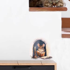Pode incluir: Um decalque de parede caprichoso com um rato lendo um livro à luz de velas em uma toca aconchegante. Acima, um gato fofo observa. A cena evoca calor e narrativa, perfeita para o quarto de uma criança ou um canto de leitura.
