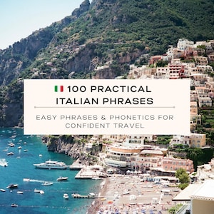 May include: Image of a coastal Italian town with a beach, boats, and buildings on a hillside. A rectangular banner displays the text "100 Practical Italian Phrases" with the Italian flag and the text "Easy Phrases & Phonetics for Confident Travel."