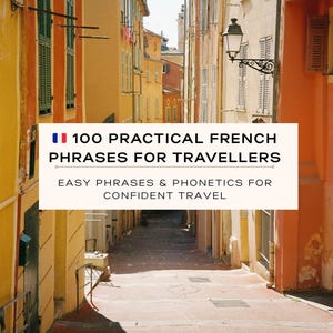 May include: A narrow European street lined with colorful buildings. A sign reads "100 Practical French Phrases for Travellers" with the French flag. The text below says "Easy Phrases & Phonetics for Confident Travel".