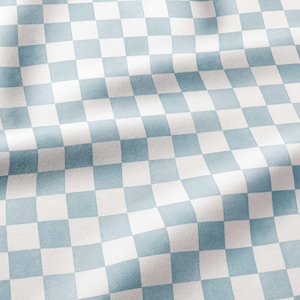 May include: A fabric featuring a repeating checkered pattern of light blue and white squares. The material displays soft folds and ripples across the surface, creating a sense of depth and texture while maintaining a consistent geometric grid design.