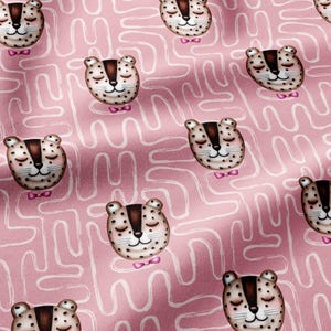 May include: A pink fabric featuring a repeating pattern of stylized leopard faces with closed eyes, brown markings, and small pink bow ties. The background is decorated with a continuous white line pattern that creates a maze-like effect across the textile.