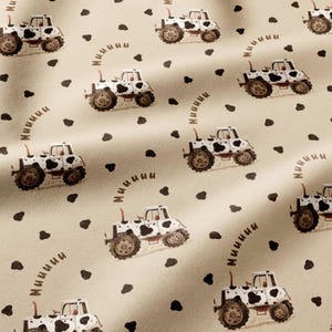 May include: A light beige fabric featuring a repeating pattern of tractors with black and white cow-print bodies. Each tractor is accompanied by the brown text "Muuuu" curving above it, interspersed with scattered black cow-print spots.