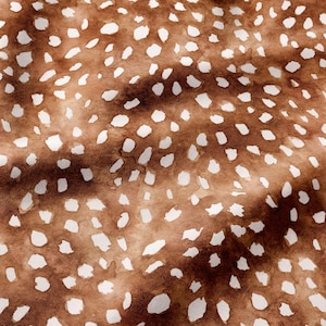 May include: A fabric featuring a brown background with a repeating pattern of irregular white spots. The design has a soft, watercolor-like appearance with subtle variations in the brown tones, creating a textured look across the surface.