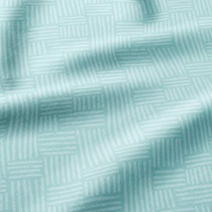 May include: A light teal fabric featuring a repeating geometric pattern of white horizontal and vertical lines arranged in small rectangular blocks. The textile has soft folds and creases that create subtle shadows across the surface texture.