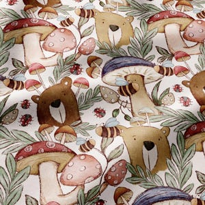 May include: A fabric pattern featuring illustrations of brown bears, red and blue mushrooms, small bees, and ladybugs on a white background. The design includes green leafy sprigs interspersed among the bears and fungi, creating a repeating woodland-themed graphic print across the textile surface.
