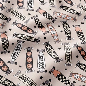 May include: A light beige fabric featuring a repeating pattern of skateboards in black, white, and peach. The skateboards display various graphics including smiley faces, skulls, checkerboard patterns, and the text GOOD VIBES, interspersed with small black stars.