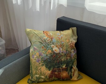 May include: A decorative throw pillow featuring a floral tapestry design. The pillow displays a vibrant bouquet of flowers in a brown pot, set against a backdrop of green and yellow hues. The pillow is placed on a yellow surface.
