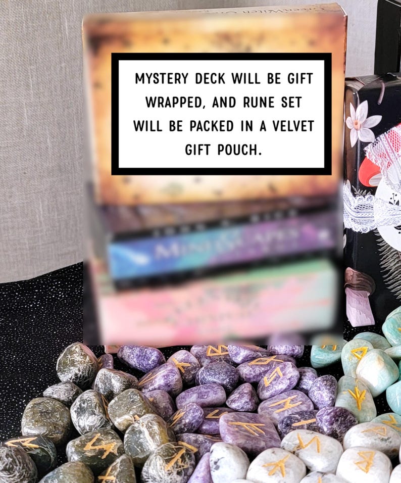 Op de afbeelding: Een verzameling runenstenen en een kaartspel. De tekst op de doos luidt: "MYSTERY DECK WILL BE GIFT WRAPPED, AND RUNE SET WILL BE PACKED IN A VELVET GIFT POUCH." De stenen zijn in verschillende kleuren, waaronder grijs, paars en groen.