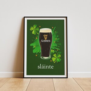 May include: A green poster featuring a glass of Guinness beer and shamrocks. The poster reads "sl&aacute;inte", which is Irish for "cheers".