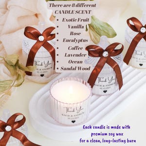 May include: Assortment of small glass candle jars with brown ribbon bows and a diamond-shaped embellishment. Each jar has a label that says "Thank You" with a name and date. The candle scents are: Exotic Fruit, Vanilla, Rose, Eucalyptus, Coffee, Lavender, Ocean, and Sandalwood. Each candle is made with premium soy wax for a clean, long-lasting burn.