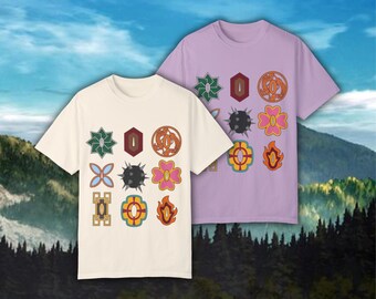 May include: Two t-shirts with a graphic design of colorful geometric shapes and symbols. The t-shirts are in a light cream color and a light purple color.