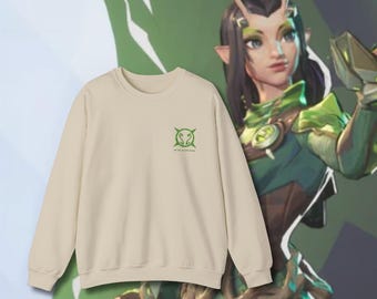 May include: A beige sweatshirt with a green graphic of a circle with four points and a snake inside. The text "We are the green machine" is below the graphic.