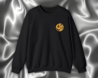 May include: Black sweatshirt with a gold embroidered design on the left chest. The design features a circle with a stylized letter "O" inside.