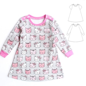 May include: A long-sleeved dress featuring a repeating pattern of cat faces in pink, white, and black on a gray background. The dress has a pink neckline and cuffs, with pink buttons on the shoulder. A pattern diagram is shown on the right.