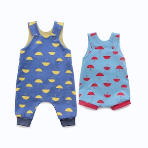May include: Two baby rompers. One is blue with yellow umbrella prints, the other is light blue with red umbrella prints. Both have a soft, comfortable design with a round neckline and short sleeves.