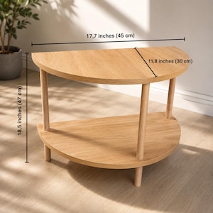 May include: A light wood semi-circular side table with two tiers and four cylindrical legs. The table measures 17.7 inches in width, 11.8 inches in depth, and 18.5 inches in height, as indicated by the visible dimension lines and text.
