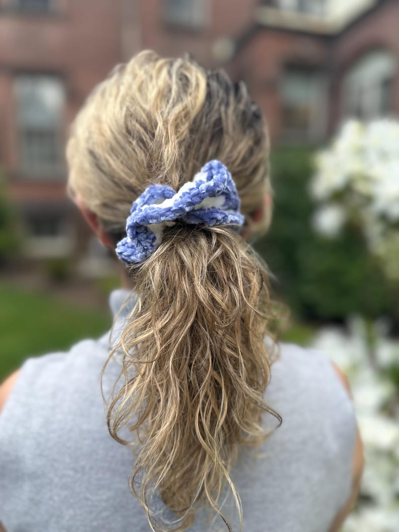 A blue and white crocheted hair scrunchie.