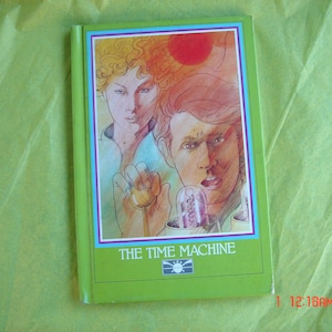 May include: A green paperback book with a colorful illustration of two people on the cover. The title of the book is "The Time Machine".