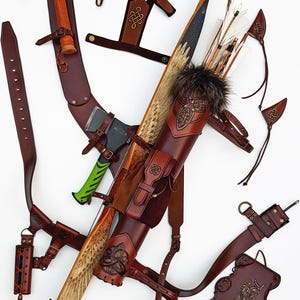 May include: An assortment of handcrafted archery equipment, including a bow, quiver, and various leather accessories. The bow features a detailed design, and the quiver is adorned with fur. The set also includes a small axe with a green handle.