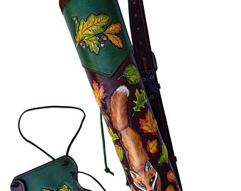 Könnte beinhalten: Handgefertigtes Leder-Bogenschieß-Set mit Köcher und Armschutz. Der Köcher ist mit einem detaillierten Fuchs- und Herbstblatt-Design in Braun-, Grün- und Orangetönen verziert. Das Set enthält einen braunen Lederriemen und einen passenden Armschutz.