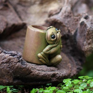 Puede incluir: Un juego de tres tazas de cerámica con un acabado mate moteado. Las tazas son de color crema, gris claro y gris oscuro. Cada taza tiene un diseño simple y minimalista, ideal para café o té.
