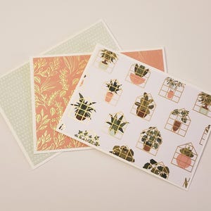 May include: Three cards with different patterns. The first card has a light green background with white polka dots. The second card has a peach background with gold leaf floral designs. The third card has a white background with gold leaf geometric designs and illustrations of potted plants.