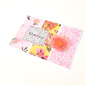 May include: A handmade thank you card with a floral design. The card features a collage of pink and yellow floral patterned paper, a pink flower, and the word "thanks" with its definition.