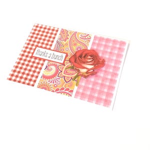 May include: A greeting card with a red and white gingham pattern, a paisley design, and a red rose. The card has the text "thanks a bunch" on a white rectangle.