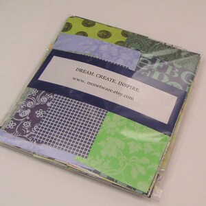 May include: A package of assorted patterned paper squares in green, blue, and purple. The package is sealed with clear plastic and has a label that reads "DREAM. CREATE. INSPIRE. www.monetware.etsy.com".