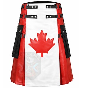 Op de afbeelding: Een kilt met een centraal wit paneel voorzien van een grote rode esdoornbladapplicatie. Het kledingstuk heeft rode zijpanelen, zwarte cargozakken met zilveren drukknopen en zwarte riemen met zilveren ringen en studs over de tailleband.