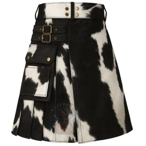 May include: A black and white cowhide kilt with a leather belt and pockets. The kilt features a buckle closure and gold-colored hardware. The kilt is a traditional Scottish garment.