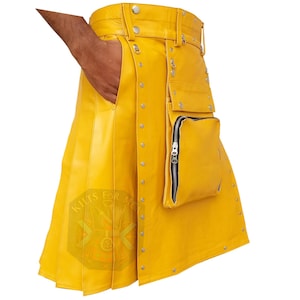Puede incluir: Un kilt de cuero amarillo brillante con remaches plateados y múltiples bolsillos. El kilt tiene un bolsillo con cremallera y un cinturón con herrajes plateados. El kilt está hecho de cuero liso y brillante.
