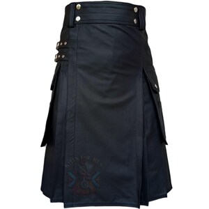 K&ouml;nnte beinhalten: Ein schwarzer Kilt mit glatter Oberfl&auml;che, hohem Bund mit silberfarbenen Metalldruckkn&ouml;pfen und seitlichen Cargotaschen. Das Kleidungsst&uuml;ck verf&uuml;gt &uuml;ber zwei verstellbare Seitengurte mit silbernen Schnallen und einen Aufdruck KILTS FOR MEN.
