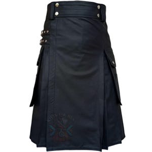 K&ouml;nnte beinhalten: Ein schwarzer Kilt mit glatter Oberfl&auml;che, hohem Bund mit silberfarbenen Metalldruckkn&ouml;pfen und seitlichen Cargotaschen. Das Kleidungsst&uuml;ck verf&uuml;gt &uuml;ber zwei verstellbare Seitengurte mit silbernen Schnallen und einen Aufdruck KILTS FOR MEN.