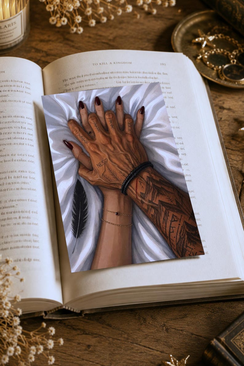 Może przedstawiać: Ilustracja dw&oacute;ch splecionych dłoni, z kt&oacute;rych jedna ma skomplikowane tatuaże i czarną bransoletkę, a druga delikatną złotą bransoletkę. Paznokcie pomalowane są na głęboki czerwony kolor. W pobliżu leży czarne pi&oacute;ro.