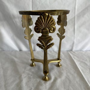 Może przedstawiać: Zestaw trzech ceramicznych kubków z nakrapianym, matowym wykończeniem. Kubki są w odcieniach kremu, jasnoszarym i ciemnoszarym. Każdy kubek ma prosty, minimalistyczny design.