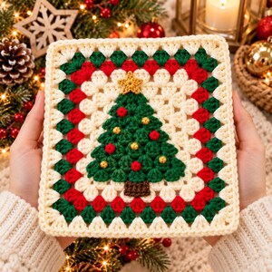 Könnte beinhalten: Ein quadratisches Häkelquadrat mit einem zentralen dunkelgrünen Weihnachtsbaum mit einem goldenen Stern an der Spitze, verziert mit kleinen roten und goldenen Kugeln. Der Rand besteht aus abwechselnden Reihen aus cremefarbenen, grünen und roten Garnen.