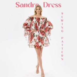 May include: An off-the-shoulder dress featuring a white base with a red rose floral print, voluminous long sleeves with tie details, and a loose silhouette. The text Sandra Dress Sewing Pattern is displayed in pink lettering on the image.