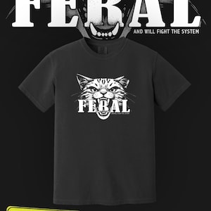 May include: A white ceramic mug with a black handle and the text "But First, Coffee" in a bold, black font. The mug is filled with a dark liquid, likely coffee, and sits on a light-colored surface.