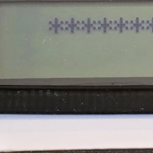 May include: A black and white digital display with a series of asterisks, "********", displayed on the screen.