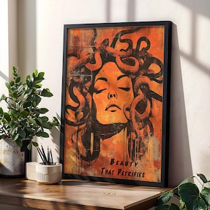 K&ouml;nnte beinhalten: Ein gerahmter Druck eines Frauenkopfes mit Schlangen im Haar. Der Hintergrund ist orange und gelb mit einem Grunge-Effekt. Der Text unter dem Bild lautet "Beauty That Petrifies".
