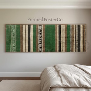 May include: A rectangular wall art piece featuring a woven textile pattern with vertical stripes in shades of green, brown, black, and cream. The design includes geometric zigzag motifs and textured bands. The text FramedPosterCo. is visible.