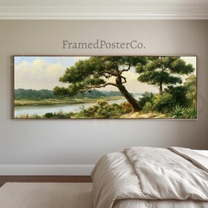 May include: A panoramic landscape painting featuring a large, dark green pine tree leaning over a calm river. The scene includes lush green foliage, distant trees, and a soft, pale sky. The text FramedPosterCo. is printed above the artwork.
