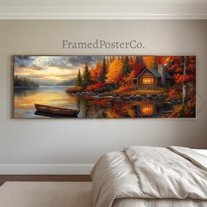 May include: A panoramic landscape wall art print featuring a wooden cabin with glowing windows nestled in an autumn forest beside a calm lake. A small rowboat floats on the water under a cloudy sky. The text FramedPosterCo. is visible above.