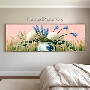 Könnte beinhalten: Ein Panorama-Wandkunstdruck mit dem Titel FramedPosterCo., der eine blau-weiße Keramikvase mit weißen Hortensien und blauen Hyazinthenstängeln vor einem zartrosa Hintergrund mit grünem Blattwerk und hohem Gras zeigt.