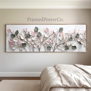 May include: A rectangular wall art piece featuring a textured white background with a gold frame. The artwork showcases a botanical design with metallic branches and leaves in shades of pink, green, and white. The text "FramedPosterCo." is visible.
