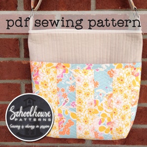 May include: A quilted fabric bag with a floral print in shades of yellow, pink, and blue. The bag has a beige top flap and a black circle logo with the text "Schoolhouse Patterns" and the tagline "Sewing is always in session".